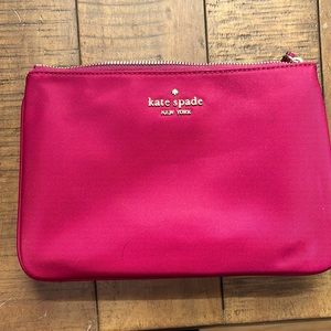 Authentic wine Kate Spade clutch in nylon, never used, with leather wrist strap.